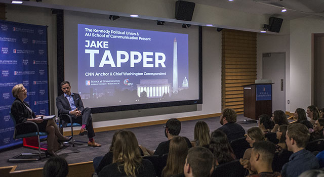 CNN Anchor Jake Tapper and SOC professor Jane Hall speak in front of an audience of students.